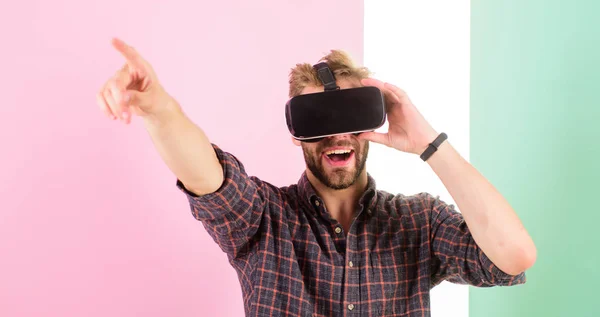 Man unshaven guy VR glasses enjoy visiting concert, pink background. Hipster use modern technologies for entertainment. VR event concept. Guy VR glasses head mounted display enjoy virtual concert