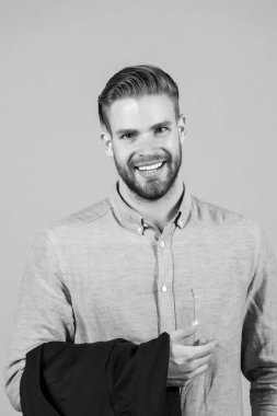 Sakallı, sarı saçlı, saç tıraşlı bir adam. Maço mutlu, mavi gömlekli, modaya uygun bir şekilde gülümsüyor. Erkek modası, tarz ve akım. Güzellik salonu, berber dükkanında bakım ve saç bakımı.