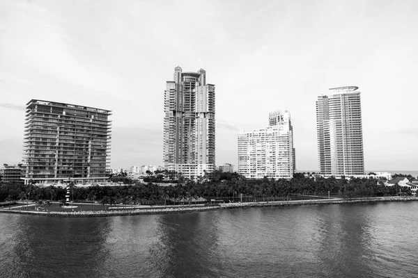 Buildings of miami, usa on sea shore. Building houses on cloudy sky