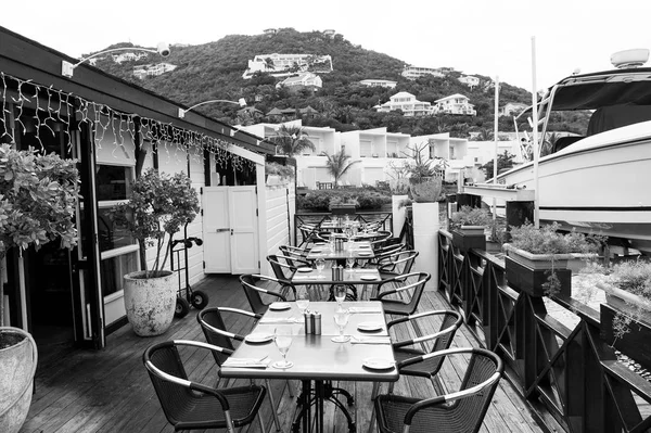 Restaurant open air in philipsburg, sint maarten. Terrace with tables, chairs and yacht in sea. Eating and dining outdoor. Summer vacation at Caribbean island, travelling. Enjoy life concept