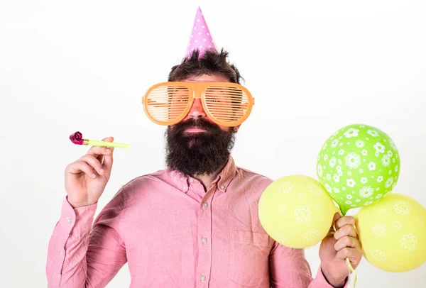 Parteikonzept. Hipster mit Riesensonnenbrille feiern Geburtstag. Mann mit Partyhut und Partyhorn feiert. Mann mit Bart und Schnurrbart auf glücklichem Gesicht hält Luftballons, weißer Hintergrund — Stockfoto