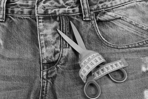 Поршневые инструменты на джинсовой ткани: ножницы и желтая лента — стоковое фото