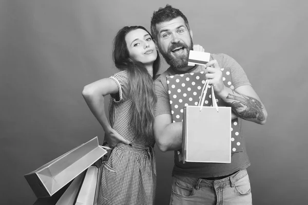 Couple hugs, holding shopping bags on green background