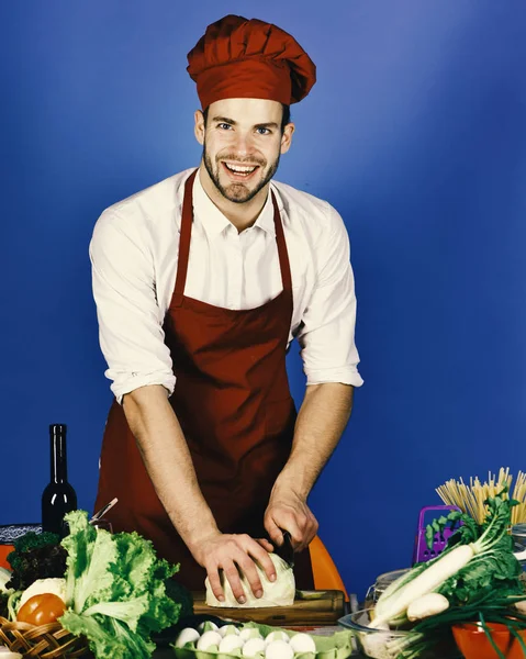 Cook arbetar i kök nära bord med grönsaker och verktyg. — Stockfoto