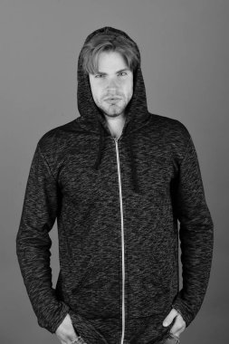 Koyu pembe arka planda, sarı saçlı bir adam.