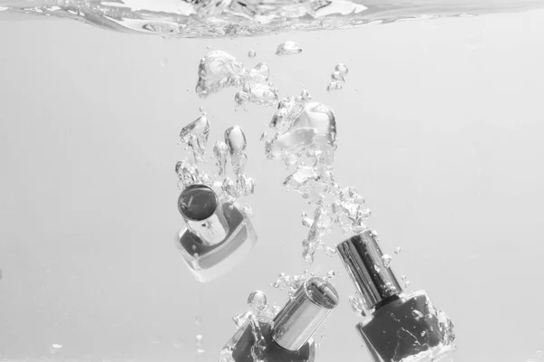 El esmalte de uñas cae en agua pura y transparente . — Foto de Stock