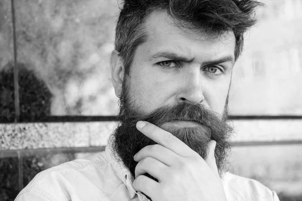 Erkeklik kavramı. Adam şüpheli görünüyor. Tousled saçlı hippi sakal mesafe içine bakarken dokunur. Sakal ve bıyık düşünceli, dalgın yüzünde siyah mermer zemin üzerine olan adam