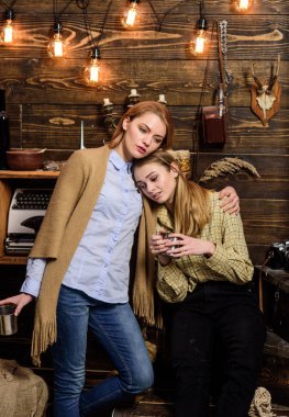 Kızlar rahat yüzleri metalik kupalar tutun, coziness içecekler tadını çıkarın. Arkadaşlar, Aile keyifli akşam, iç arka plan geçirmek. Arkadaşlar hugs süre var içten konuşma. Dedikodu görüşmeler kavramı