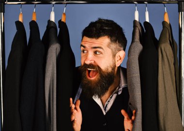 Tezgahtar ya da satıcı elbise askılarında takım elbiselilerin arasına saklanır.