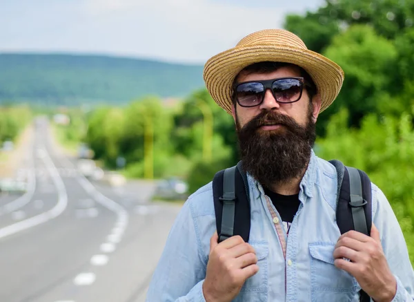 Dicas de viajante experiente. Homem barbudo hipster mochileiro na beira da estrada. Leva-me contigo. Viajante à espera de carro levá-lo de qualquer maneira apenas para cair em melhor lugar. Procure companheiros de viagem — Fotografia de Stock