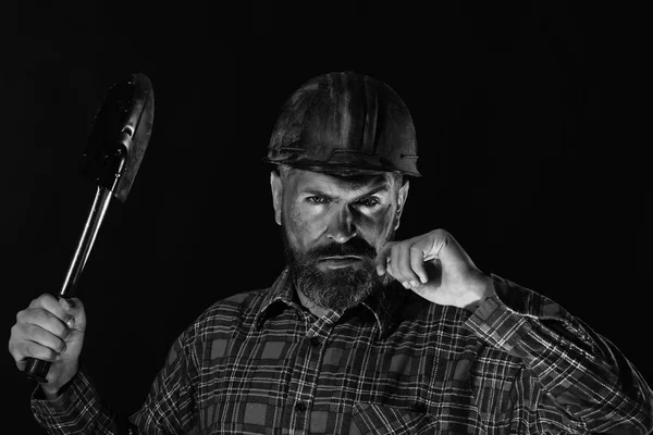 Guy with brutal image wears dirty helmet and holds shovel — Stock Photo, Image