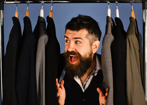 Tezgahtar ya da satıcı elbise askılarında takım elbiselilerin arasına saklanır.