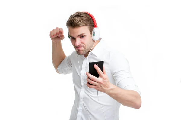 Ця пісня скелі. Чоловік слухає улюблені навушники пісні зі смартфоном. Навушники хлопця слухають рок-музику. Людина зосереджена обличчям насолоджуватися прослуховуванням музики ізольованого білого фону. Рок-радіо канал — стокове фото