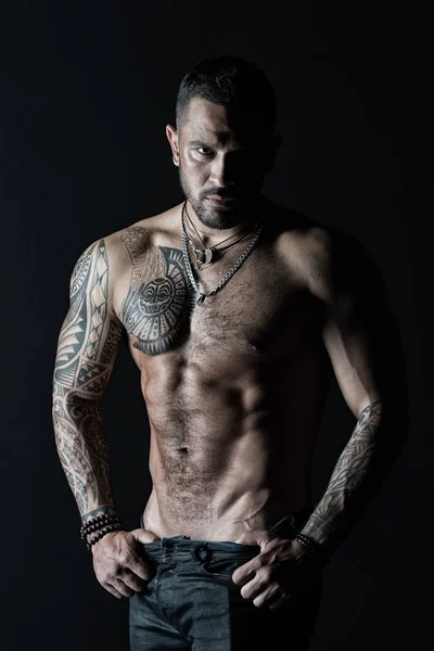 Atleta con muscoli bicipiti e tricipiti. Uomo spogliarellista mostra busto sexy. Sportsman con sei pack e addominali stripping. Uomo di moda con tatuaggio decollare jeans. Desiderio e attrazione nel filtro vintage — Foto Stock