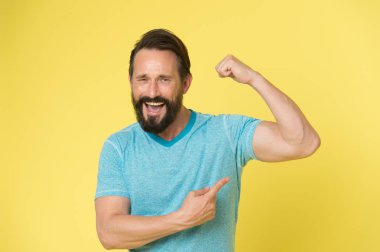 Fitness sonucu. Adam fitness eğitiminden sonra kas gücünü gösterir. Mutlu adamın fitness sonucu. Pazılara bakan adam formda olduğunu gösteriyor. çalışma sonuçları.