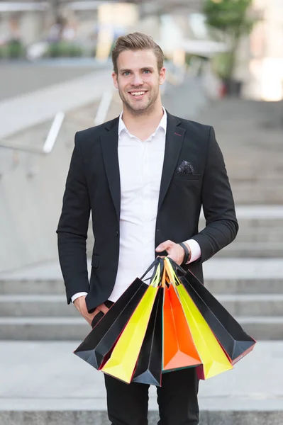 Shopping esclusivo. Uomo shopper porta borse della spesa sfondo urbano. Uomo d'affari di successo scegliere solo marchi esclusivi di lusso e shopping in boutique di alta moda. Boutique galleria cliente — Foto Stock