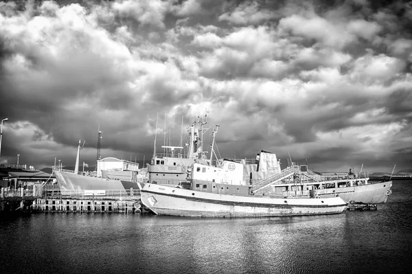 Reykjavik, Islândia - 14 de outubro de 2017: navios no cais do mar em pequena aldeia. Navios de mar em costa em céu nublado. Transporte aquático e marítimo. Férias ou desejo de viajar e viajar — Fotografia de Stock