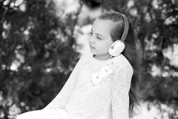Ragazzo di moda e tecnologia moderna. Suono melodico e mp3. La ragazzina ascolta musica nel parco estivo. Bambino godere di musica in cuffie all'aperto. Vacanze estive riposo e divertimento — Foto Stock