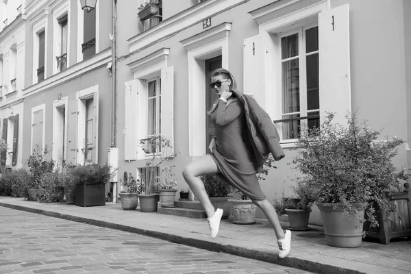 Mujer sexy saltar en la calle de París, Francia, vacaciones. Mujer con gafas de sol, vestido rojo, zapatillas en la calle, moda. Belleza, mira, maquillaje. Moda, moda, estilo. Vacaciones, viajes, ansia de viajar — Foto de Stock