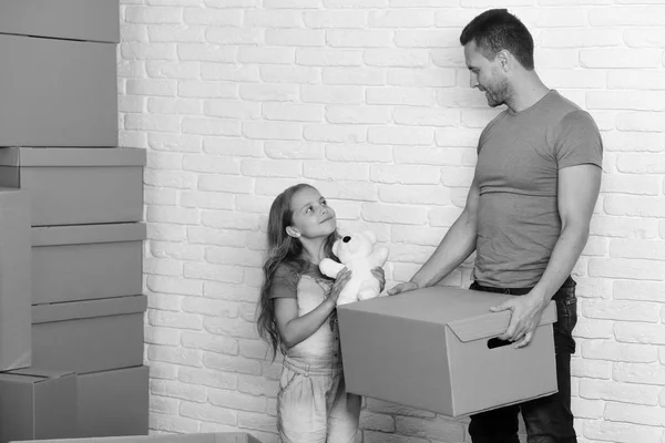 New home and family concept. Daughter and father hold box