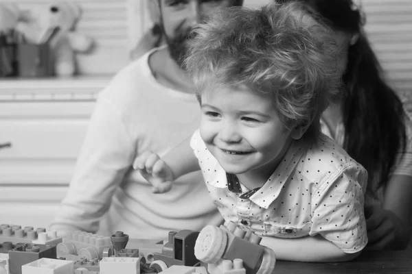 I genitori guardano il loro figlio giocare con blocchi colorati . — Foto Stock