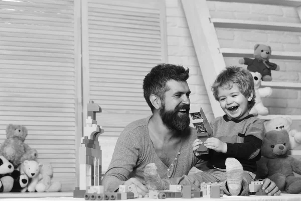 Jongen en bebaarde man spelen samen op houten muur achtergrond — Stockfoto