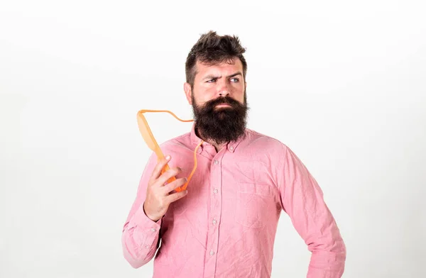 Homem com barba e bigode no rosto pensativo usa óculos engraçados, fundo branco. Hipster a espreitar de óculos de sol gigantes. O tipo com barba segura os óculos. Conceito de óptica e óculos — Fotografia de Stock