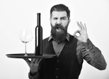 Sakallı bir adam beyaz arka planda alkollü bir şişe tutuyor..