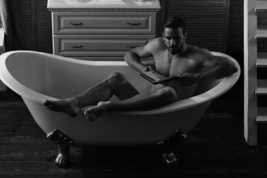 Adam sakal ve düşünceli yüz okuma kitabı küvet içinde