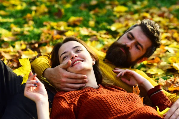 Мужчина и женщина с счастливыми лицами на траве и листьях — стоковое фото