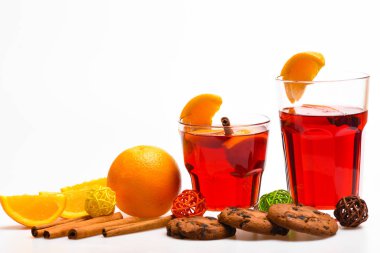 İçki ya da portakal ve tarçın ile içecek. Kokteyl bar kavramı ve. Portakal dilim yakınındaki mulled şarap. Gözlük mulled şarap veya portakal dilimleri ve çerezleri beyaz arka plan üzerinde yakın sıcak elma şarabı ile