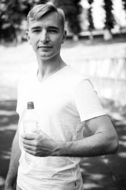 Sporcu plastik şişe güneşli açık ile. Susuz adamın su şişesi Stadı ile. Susuzluk ve dehidrasyon. İçme suyu sağlık için. Spor aktivitesi ve enerji