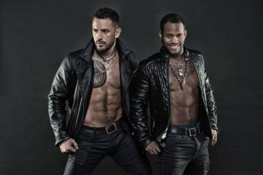 Modeller çıplak torsolar, moda kavramı deri ceket giyiyor. Altı paket ve dövmeli sandıkları motorcularla. Afrika adam beyaz bir gülümseme ile. Küçük kıl beyaz adamla. Bodybuilders seksi organları ile