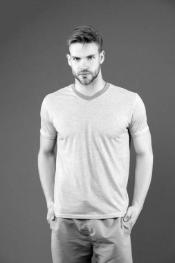 Mor arka planda tişörtlü ve şortlu bir adam. Mavi günlük giysili adam. Antrenman için aktif giyinmiş maço ya da mor arka plan eğitimi almış. Spor modası ve moda. Fitness ve spor salonu aktivitesi