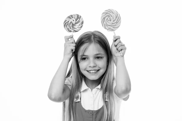 Lustiges Mädchen, das mit wirbelnden Karamellen lächelt. Kleine Kinder lächeln mit Bonbons auf Stöcken auf weißem Grund. süß und extrem groß. glückliches Kinderlächeln mit Lutschern. Essen und Dessert. Ernährung und Diät — Stockfoto