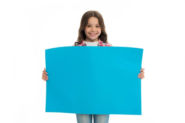 Реклама на дитячому ринку. Дівчинка тримає синій пустий простір для копіювання поверхні. Концепція реклами. Дитяча мила дівчина виглядає щасливою, коли носить блакитний папір. Дитяче веселе обличчя щира рекомендація — стокове фото