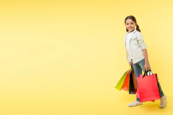 Giornata di shopping. giornata di shopping con bambino felice. bambina sorridente il giorno dello shopping. ragazza con i pacchetti dopo la giornata di shopping, copiare lo spazio. — Foto Stock