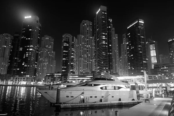 Dubai, Emiratos Árabes Unidos - 26 de diciembre de 2017: club náutico en el distrito de Dubai Marina por la noche. Barco de yate en skyline con iluminación. Transporte y transporte por agua. Viaje o viaje y viaje — Foto de Stock