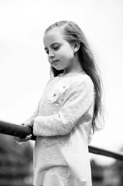 Μικρό κορίτσι σε μοντέρνα ρούχα στο φυσικό υπόβαθρο. Παιδί με εξωτερική μακριά ξανθά μαλλιά. Παιδί μοντέρνο φόρεμα μοντέλο. Μόδα στυλ και η τάση. Χάνεται σε σκέψεις. Παιδικής ηλικίας και της φροντίδας των παιδιών — Φωτογραφία Αρχείου