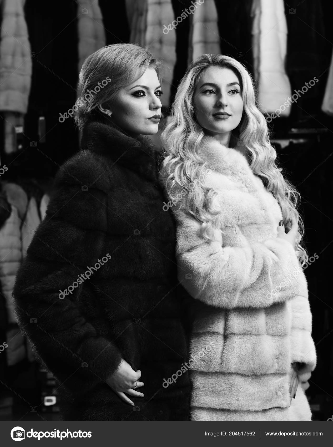 Girls With Strict Faces In Black And White Fur Coats Stock Photo