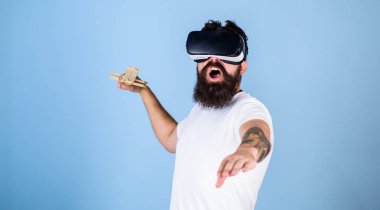 Hipster yüz bağırarak üzerinde sanal gerçeklik oyun oyun keyfini çıkarın. Vr gözlük, açık mavi renkli sakallı adam. VR oyun kavramı. Adam ile kafa monte göstermek ve kılıç oyun Vr oyun mücadele