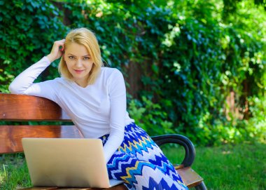 Avantajları ve dezavantajları olma Freelancer. Bayan, serbest meslek sahibi Park'ta çalışma. Serbest faydaları. Kadın dizüstü bilgisayar ile açık, yeşil doğa arka çalışır. Kız oturup Not defteri ile tezgah