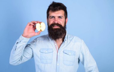 Adam gülümseyen tutan apple mavi arka plan sakallı. Yarım elma sağlıklı yaşam tarzı. Besin değeri kavramı. Vitamini beslenme diyet sağlık. Hipster doğal ekolojik elma gösterir