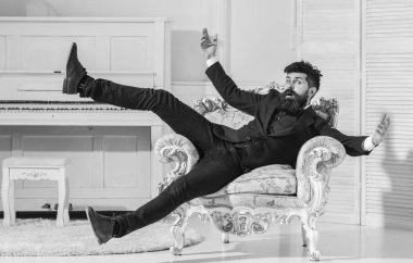 Maço çekici ve zarif neşeli yüzü ve sürpriz ifade. Moda ve stil kavramı. Adam oturuyor sakal ve bıyık moda klasik takım elbise ile eski moda koltukta atlar