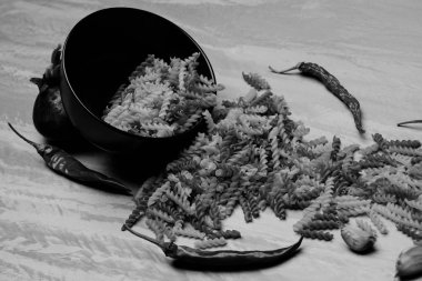 Yemek pişirme malzemeleri ve siyah seramik tabakta İtalyan makarnası.