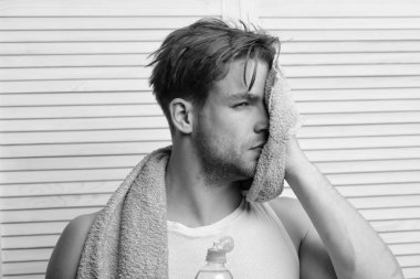 Su şişesi ve yeşil havlusu olan adam.