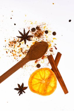 Baharat Seti kavramı. Baharatlar, kurutulmuş portakal, tarçın, kakule ve beyaz zemin üzerine Hindistan cevizi kaşıkla. Mulled şarap baharat seti. Baharat seti hazırlamak için mulled şarap ya da sıcak içecek, yakın çekim