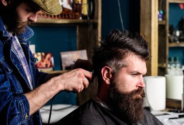 Hipster istemci Başlarken saç kesimi. Kuaför saç kesme makinesi ile saç modeli sakallı, berber arka plan için çalışır. Saç kesimi kavramı. Kuaför saç modeli sakallı yetişkin adam, kırpma makası kullanarak yapar