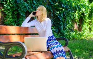 Teknolojileri hayat kolaylaşır. Kadın dizüstü bilgisayar ile açık havada çalışır. İş kadını uzak sorunlarını çözme. Kız akıllı telefon çağrı iş sorunu çözmek. İş kadını park dizüstü smartphone ile çalışır