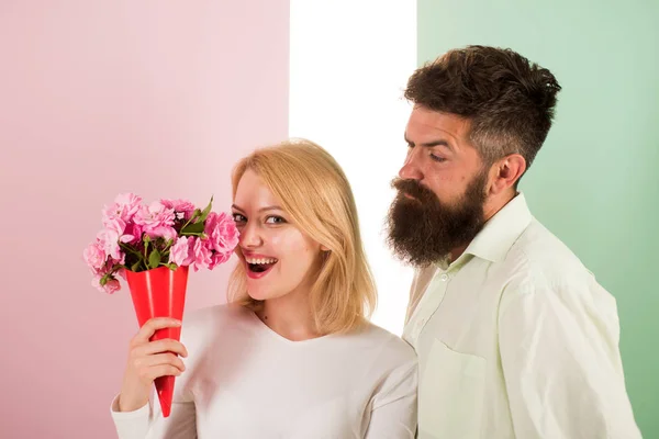 Woman enjoy fragrance bouquet flowers. Man with beard takes care about girlfriend happiness. Lady likes flower husband gifted her. Flowers delivery concept. Couple in love happy celebrate anniversary — Stock Photo, Image